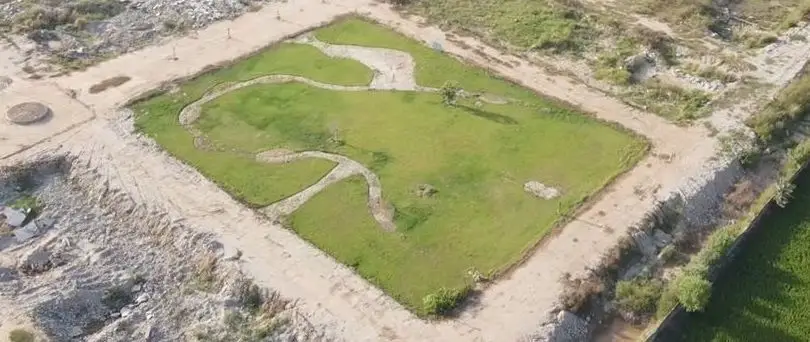 Park lawn and walking path, from above, Kunjwal City, September 2026